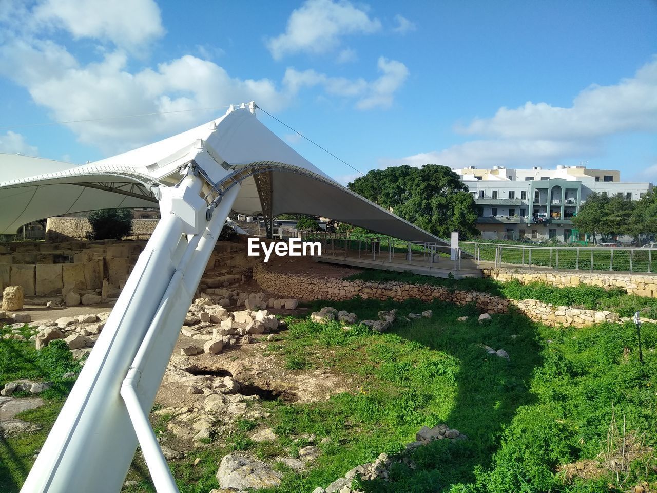 Built structure on field by buildings against sky