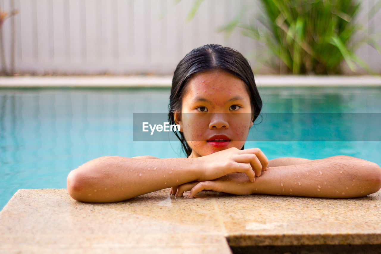 Portrait of asian woman standing on the edge of pool