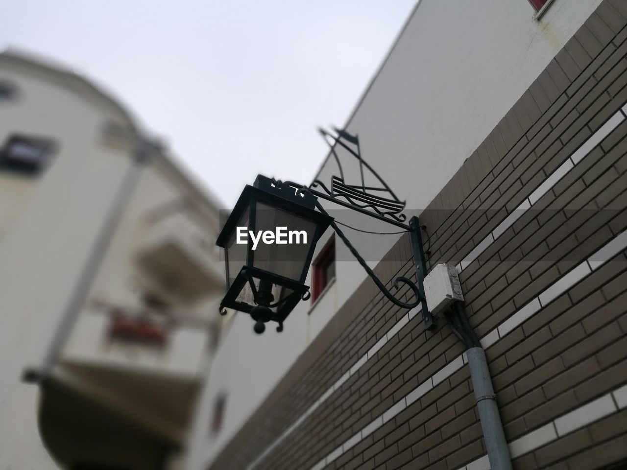 LOW ANGLE VIEW OF STREET LIGHT AGAINST BUILDINGS