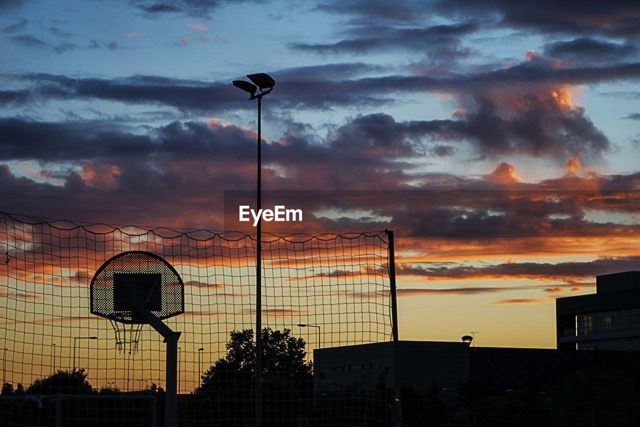 LOW ANGLE VIEW OF BASKETBALL HOOP AGAINST SKY DURING SUNSET