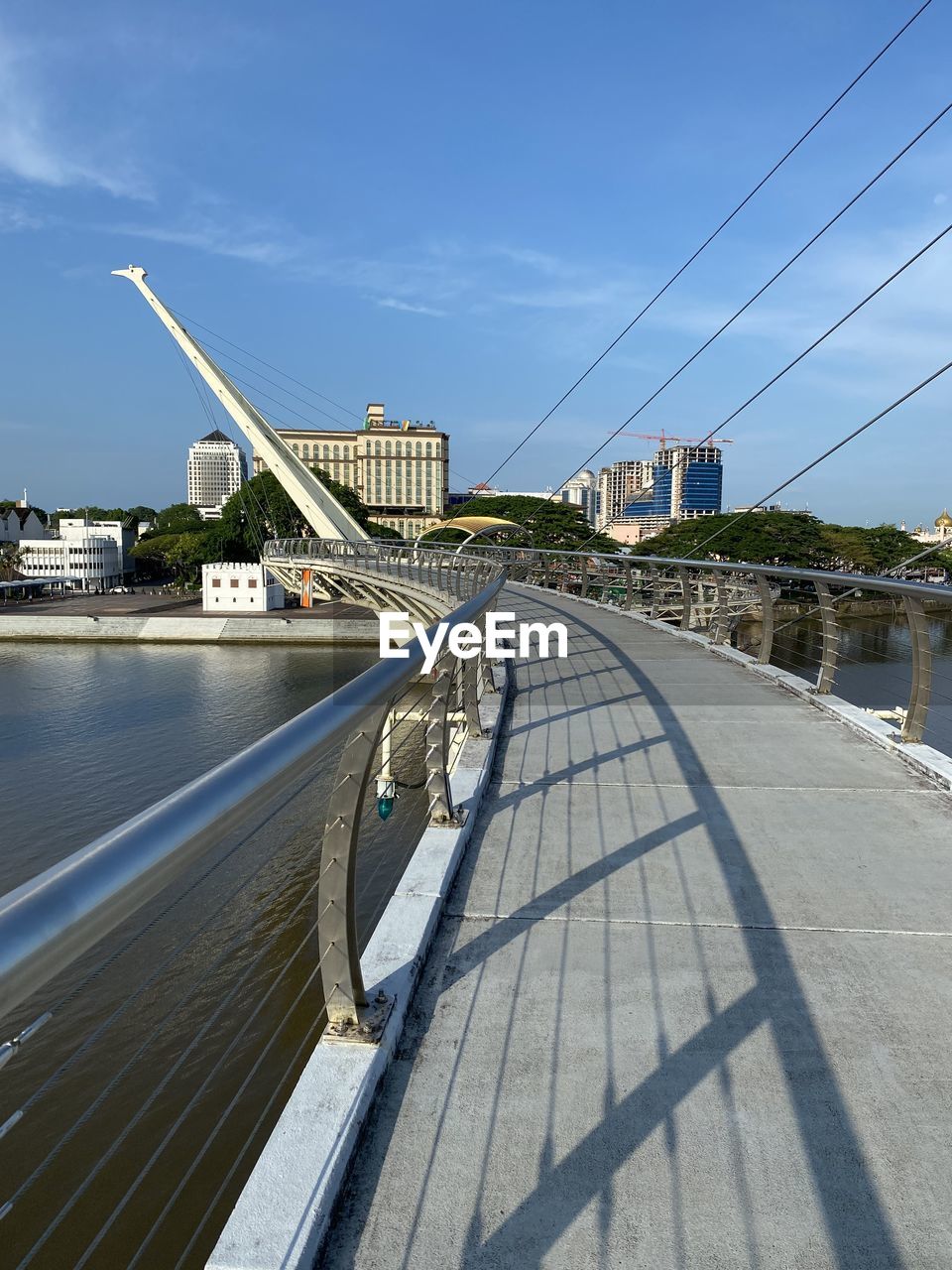 architecture, built structure, sky, transportation, nature, day, blue, skyscraper, city, mast, building exterior, bridge, outdoors, sunlight, vehicle, travel, no people, low angle view, power generation, mode of transportation, cable, technology