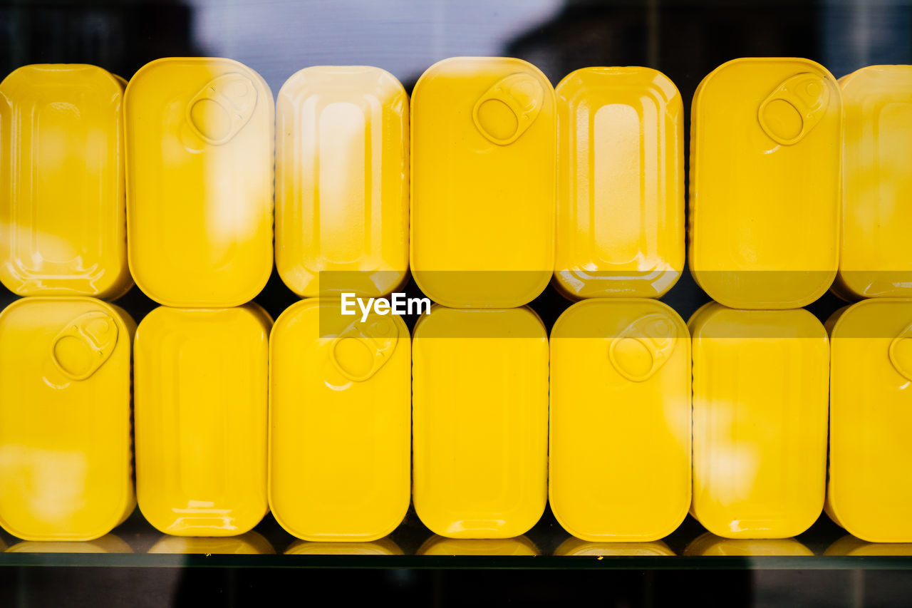 Close-up of yellow containers seen from glass