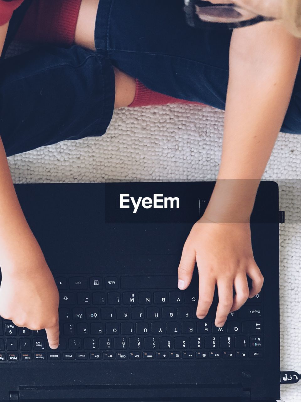 Midsection of child using laptop at home