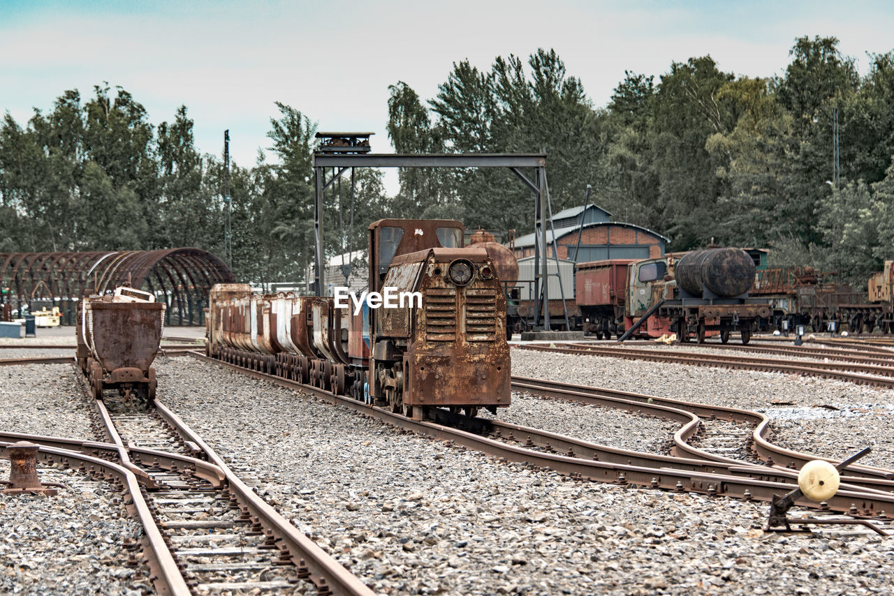 TRAIN AT RAILROAD TRACKS AGAINST SKY