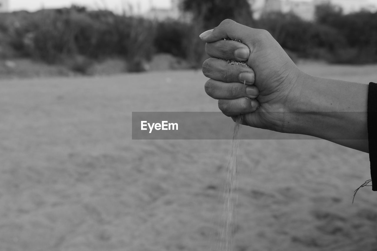 Close-up of hand holding sand