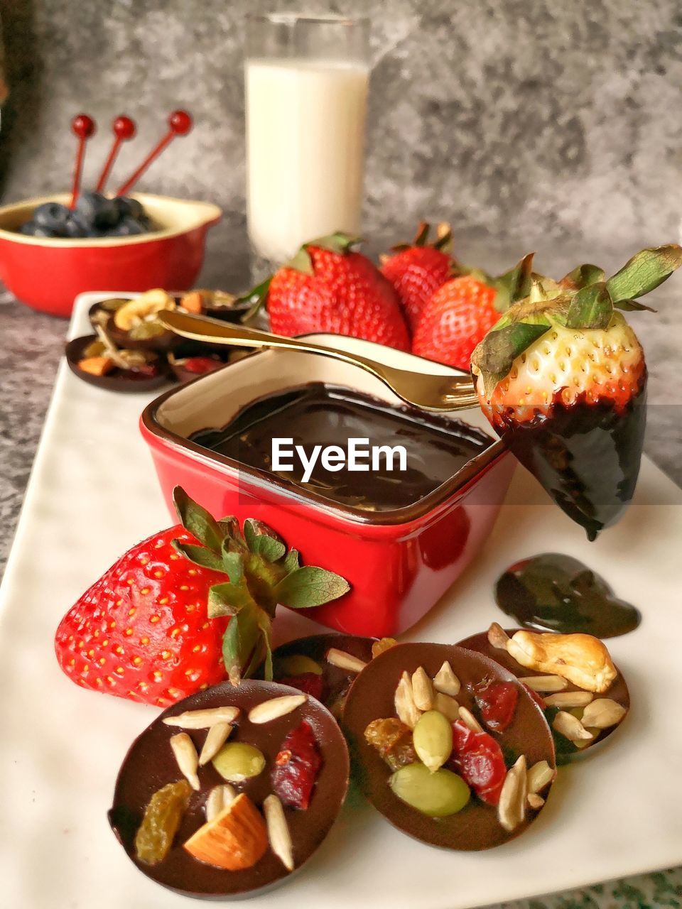 High angle view of cookies with chocolate and strawberries in plate on table