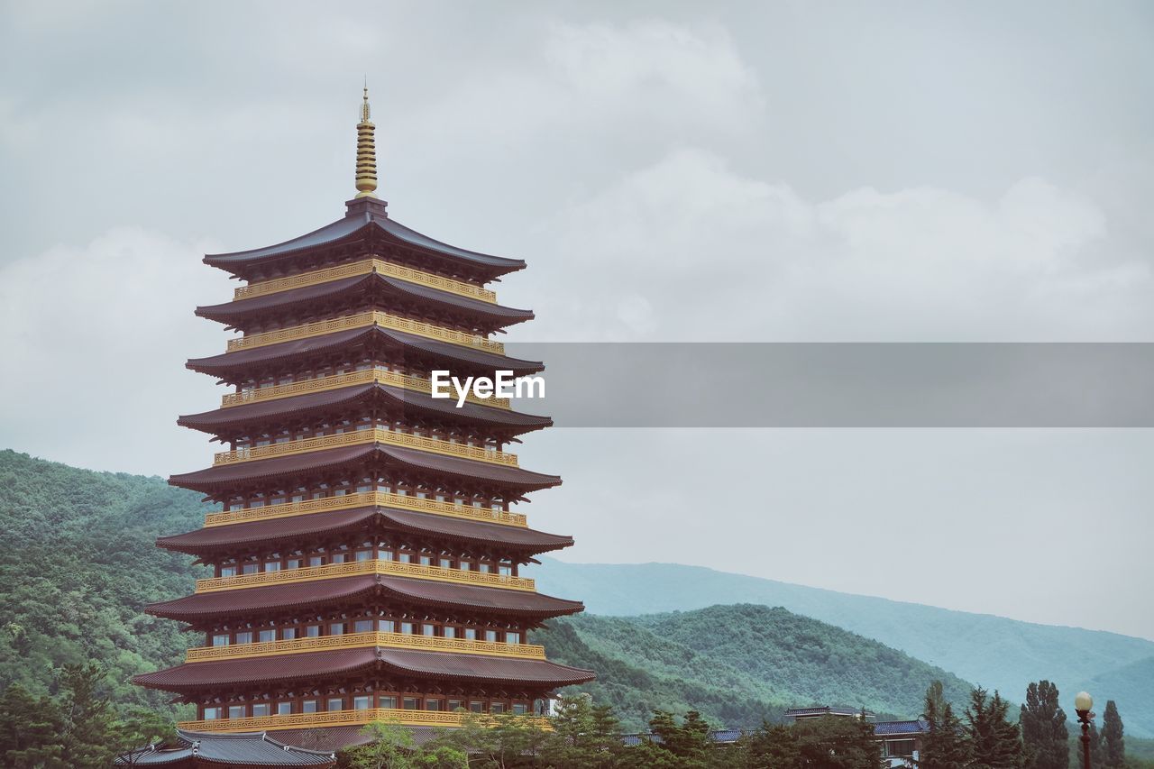 Temple by mountain with sky in background