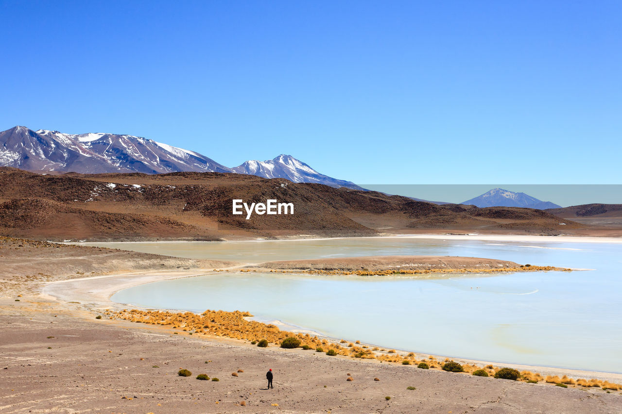 SCENIC VIEW OF LAKE AND SNOWCAPPED MOUNTAINS AGAINST CLEAR BLUE SKY