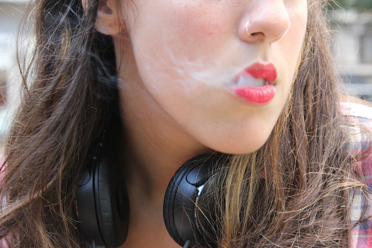 Close-up of young woman with nose ring and headphones