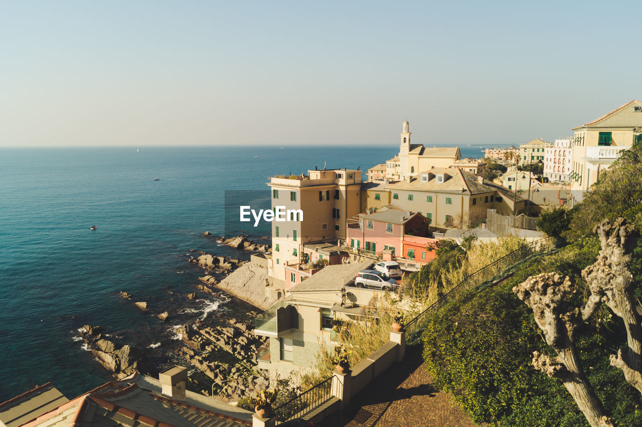 HIGH ANGLE VIEW OF BUILDINGS AND SEA AGAINST SKY