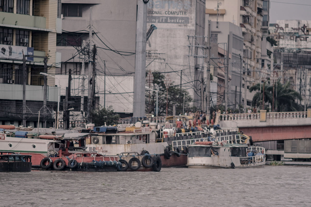 NAUTICAL VESSEL ON RIVER BY BUILDINGS IN CITY