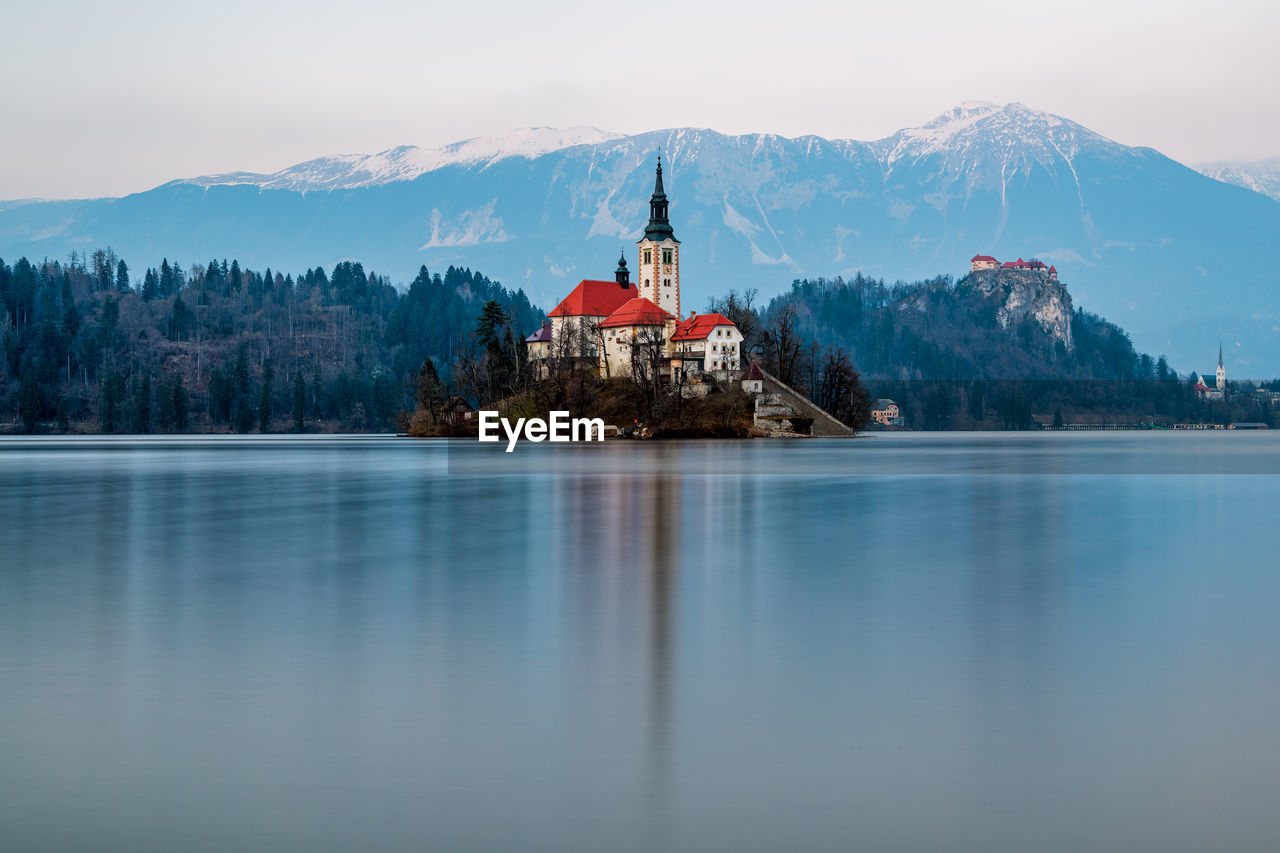 Scenic view of lake by building against sky