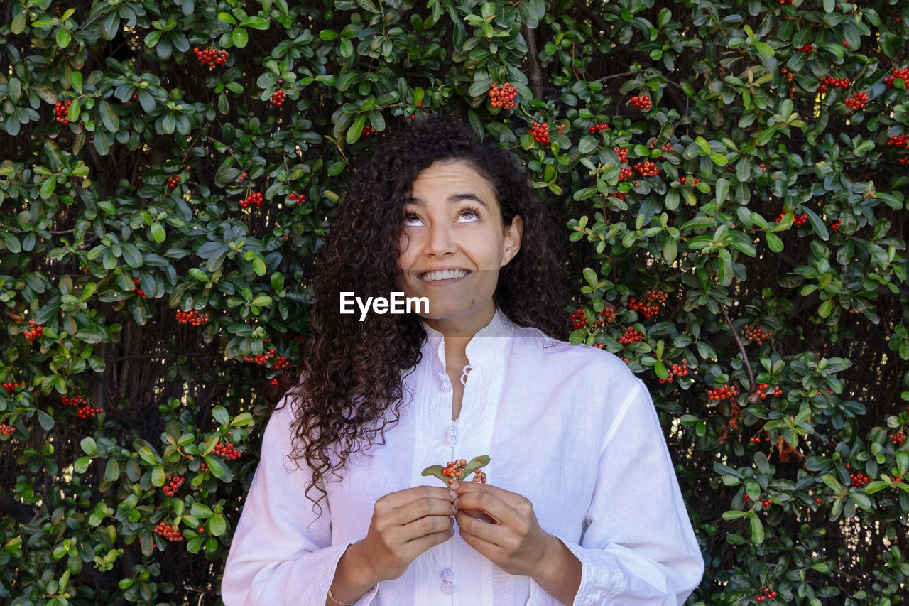 Smiling woman standing by plants