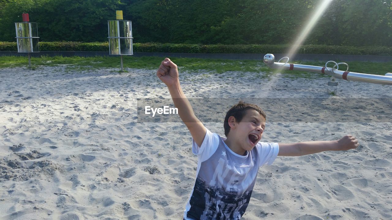 FULL LENGTH OF GIRL PLAYING WITH ARMS RAISED IN PARK