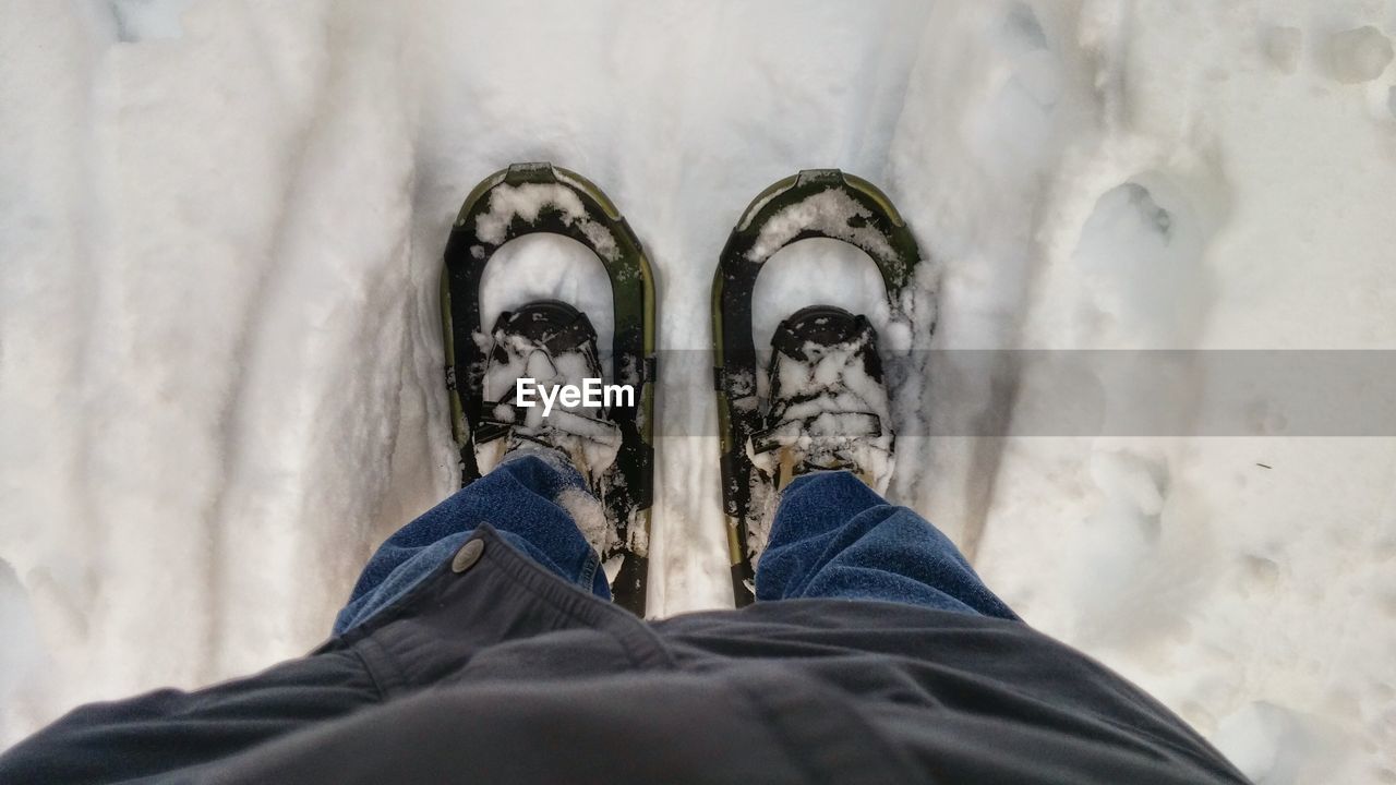 Low section of person wearing snowshoe on field