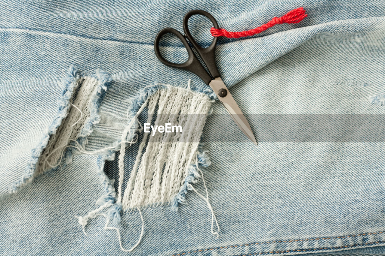 High angle view of scissors on jeans