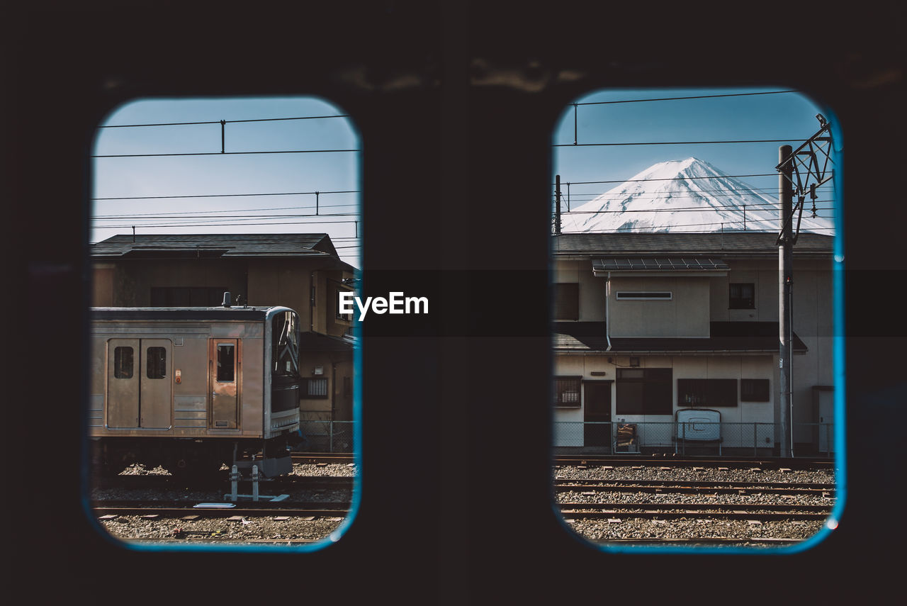 Train and snowcapped mountain seen through window