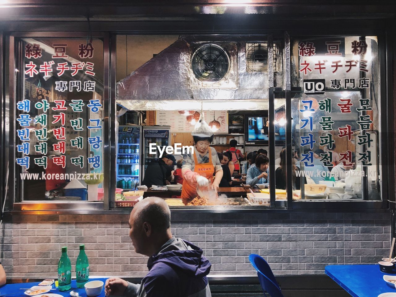 REAR VIEW OF PEOPLE WITH TEXT ON GLASS