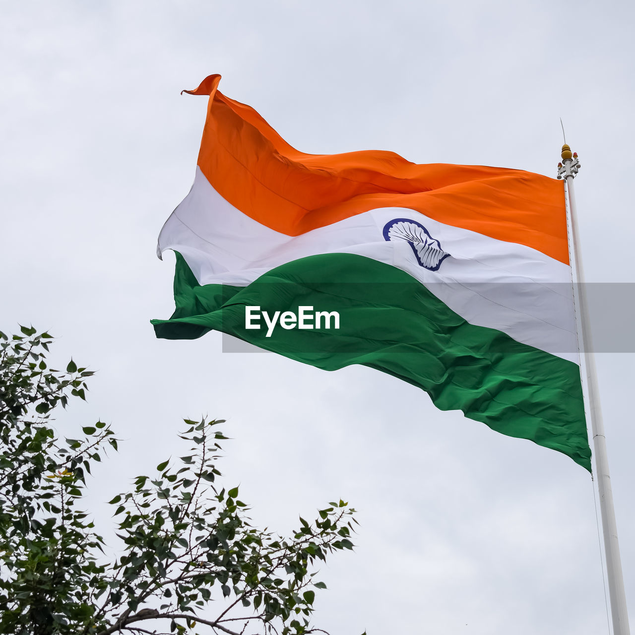 India flag flying high at connaught place with pride in blue sky, india flag fluttering, indian flag