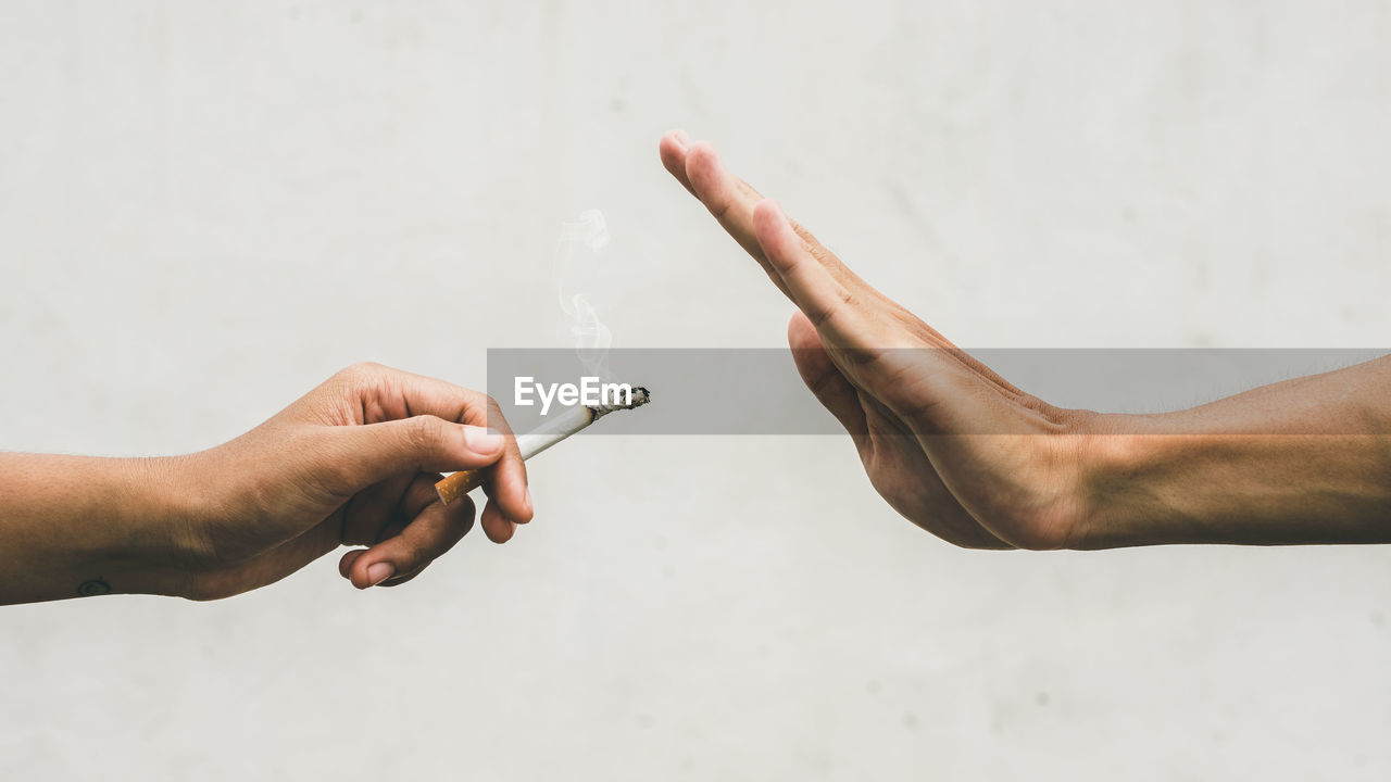 Close up hands of person refusing to smoke cigarette. negative attitude to smoking. quitting smoking