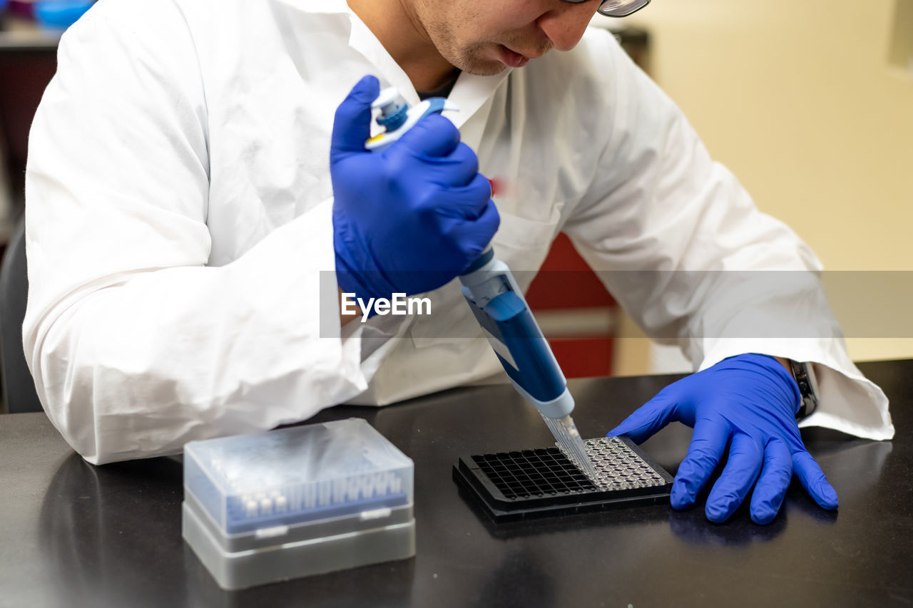 Midsection of scientist working in library