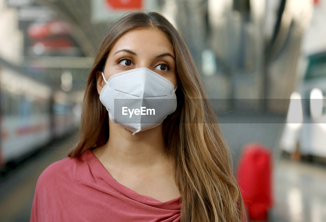 Close up of girl waiting metro wearing protective face mask at subway station