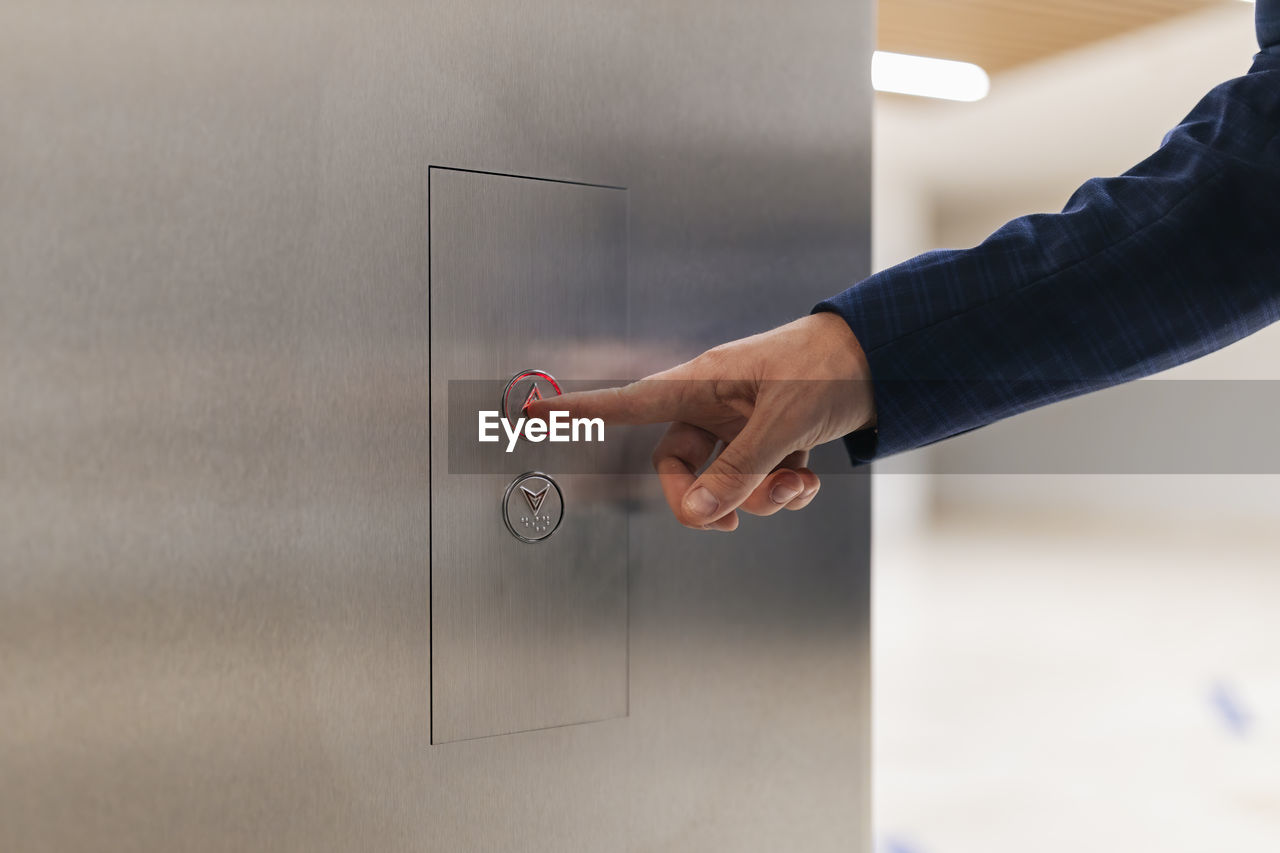 Businessman using elevator push button