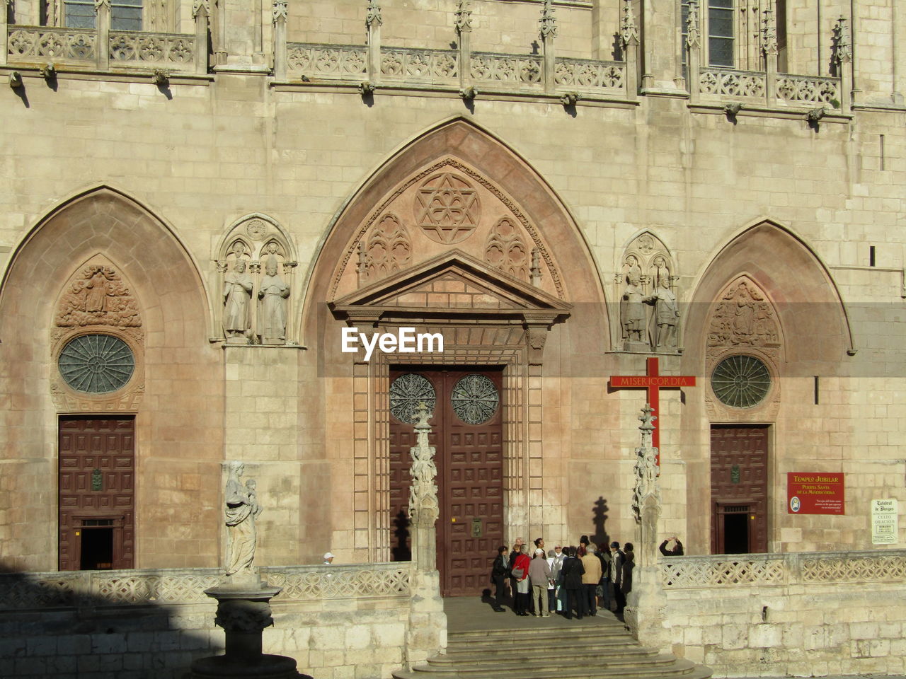 GROUP OF PEOPLE WALKING IN FRONT OF CATHEDRAL