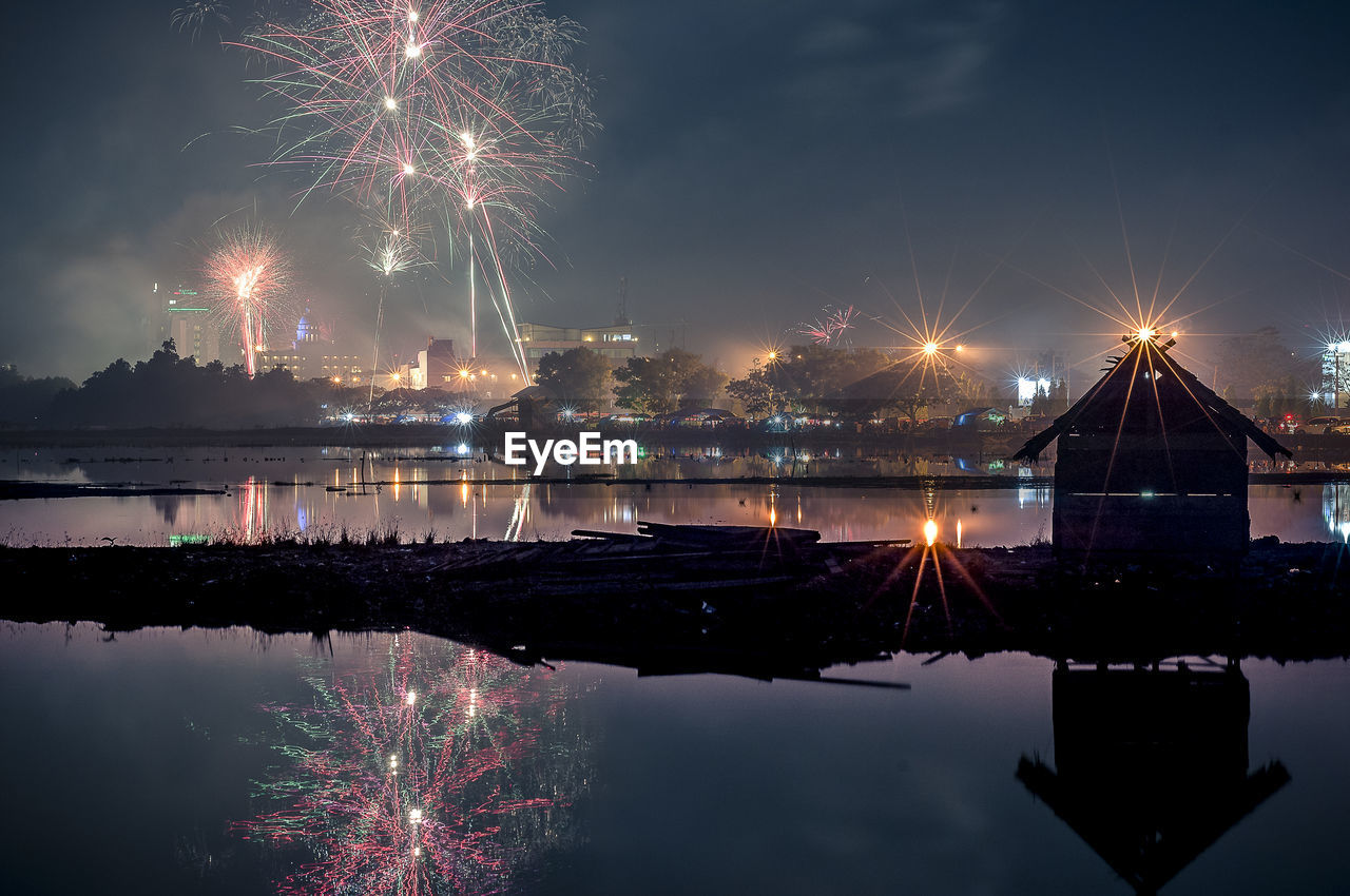 Firework display over illuminated city at night