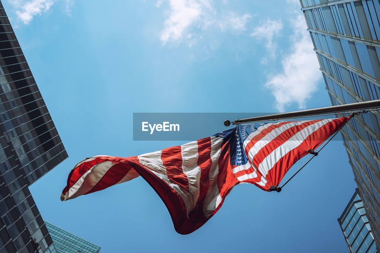 Low angle view of american flag hanging against sky