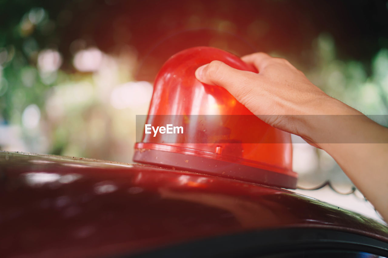 Close-up of hand holding police siren