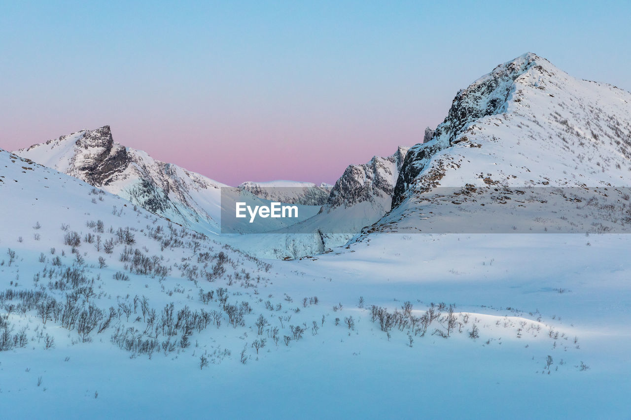 Scenic view of snow covered mountains against sky during sunset