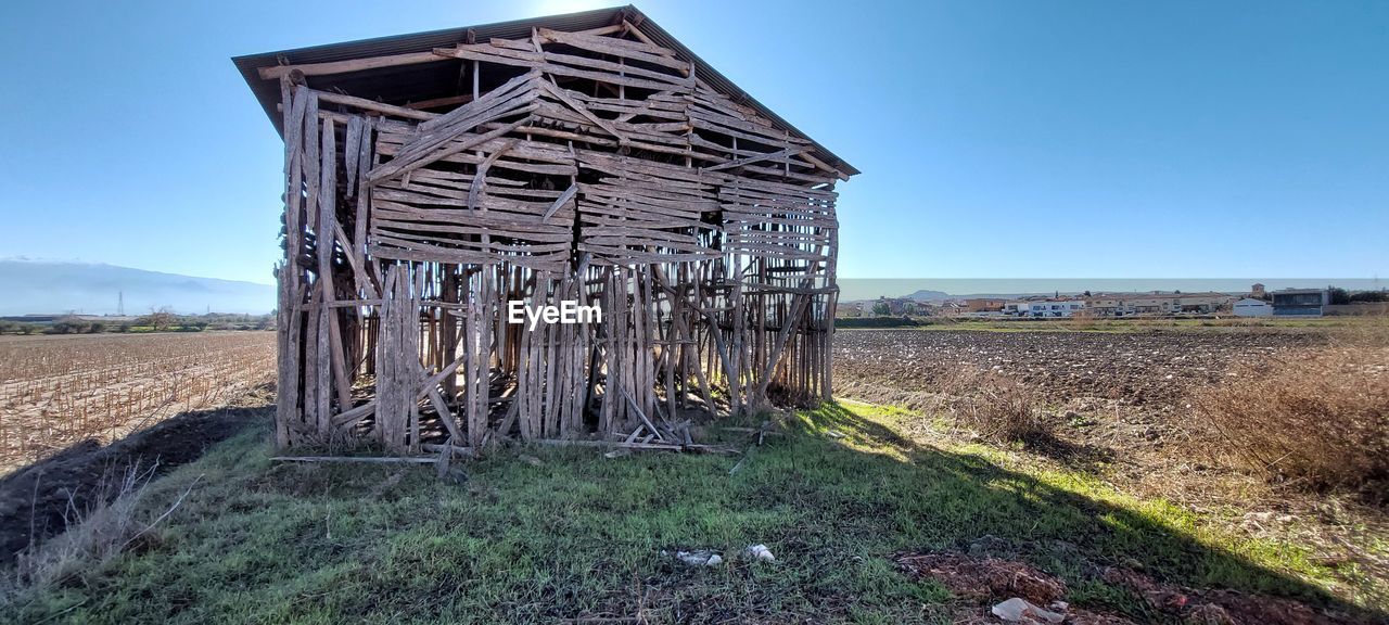 sky, architecture, built structure, nature, landscape, land, no people, blue, day, wood, plant, clear sky, rural area, rural scene, field, building exterior, abandoned, grass, environment, building, outdoors, agriculture, farm, hut, sunlight, sunny, ruins, scenics - nature, rundown