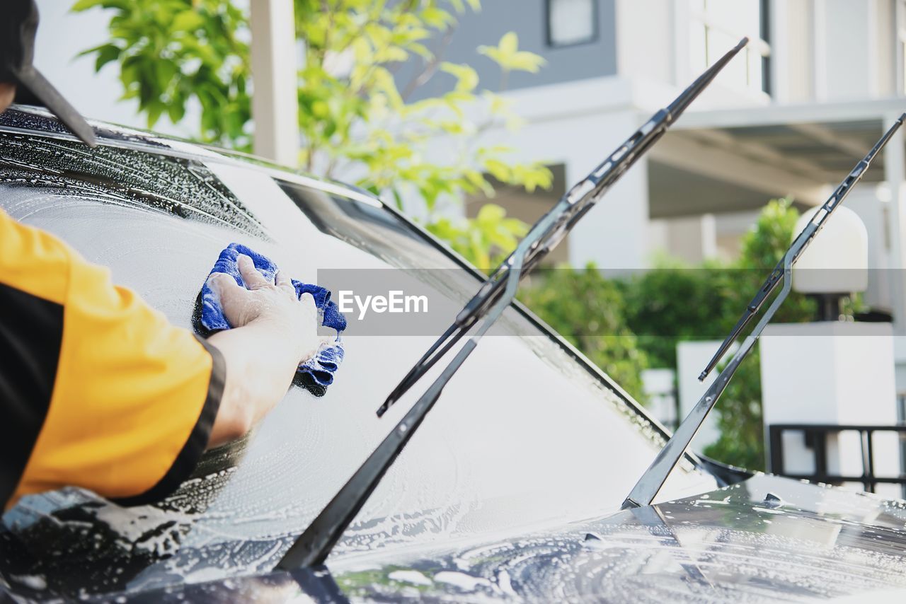 Man wash car using shampoo - every day life car care concept