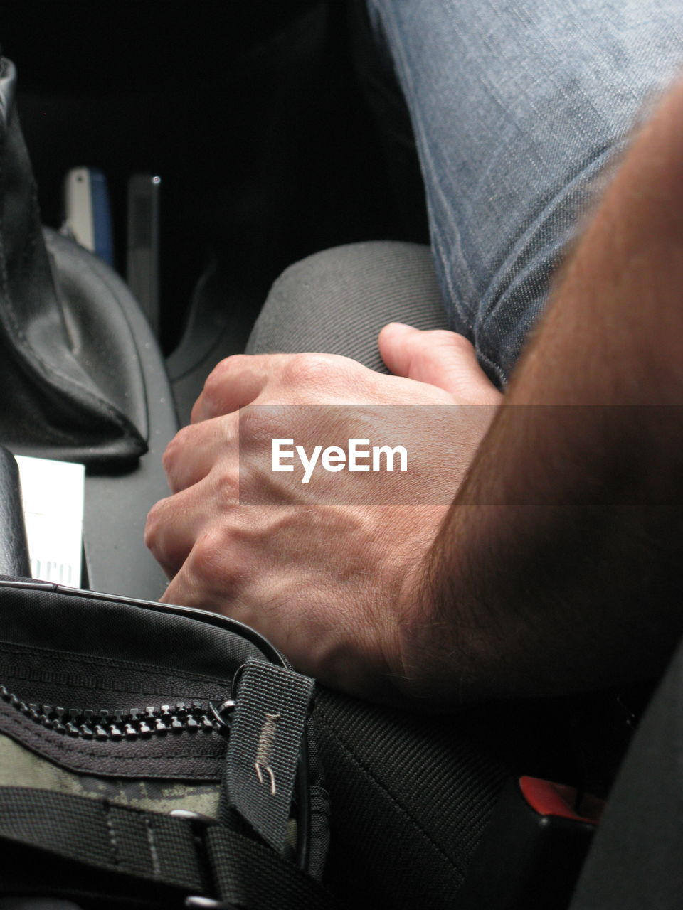 MIDSECTION OF MAN SITTING ON SEAT IN BUS