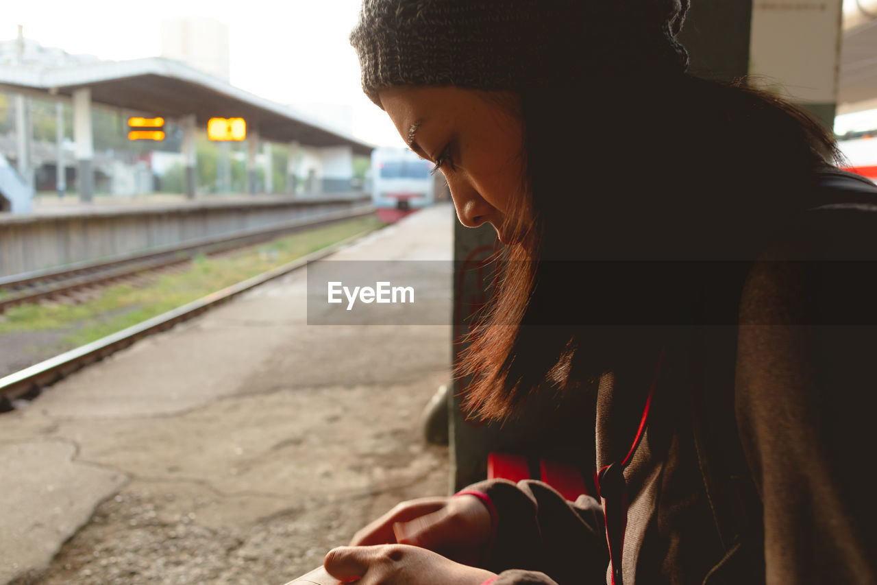 Woman sitting at railroad station