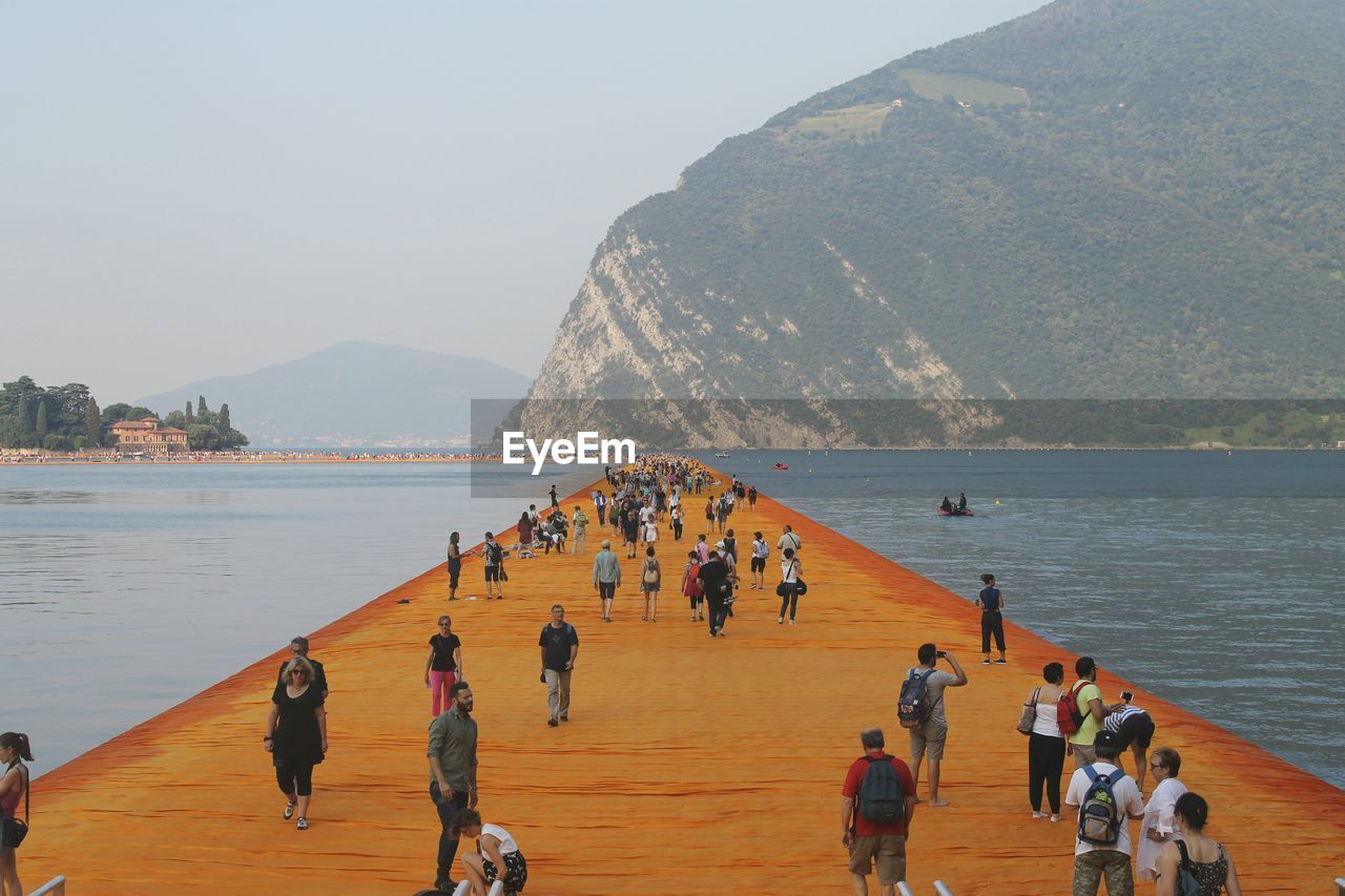 PANORAMIC VIEW OF PEOPLE ON BEACH AGAINST SKY