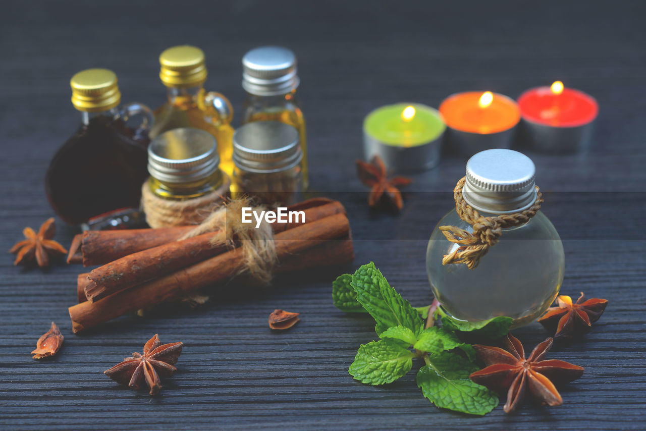 Close-up of oils with spices and herbs on table