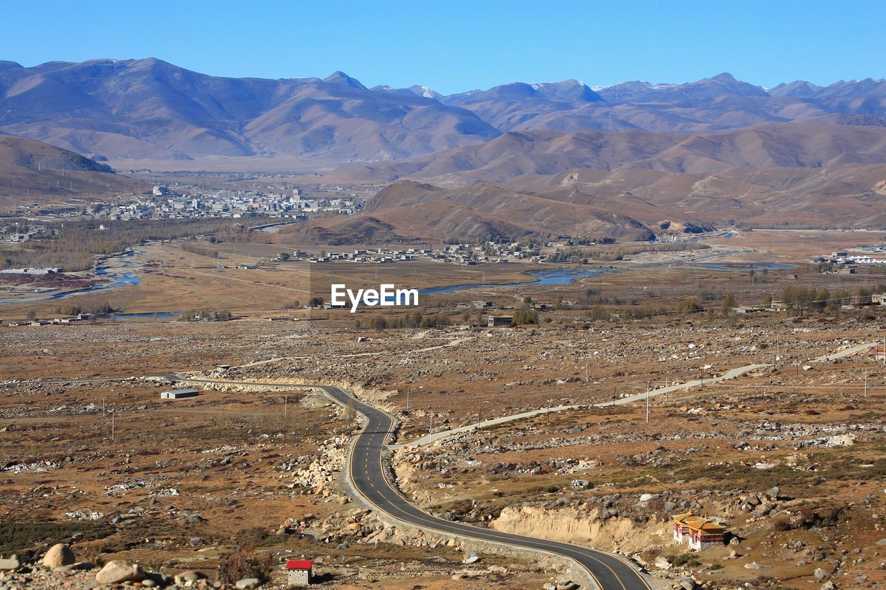 HIGH ANGLE VIEW OF ROAD AMIDST MOUNTAINS AGAINST SKY