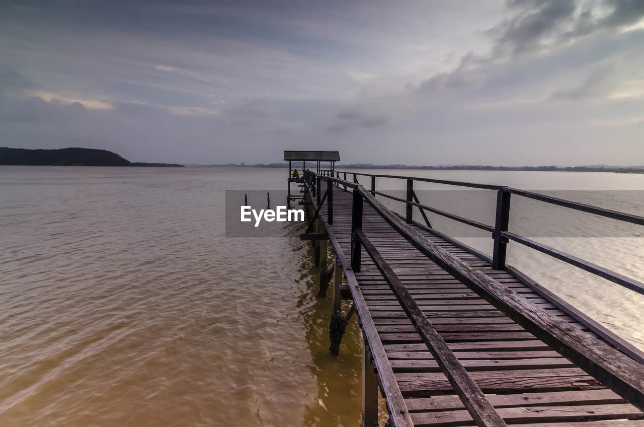 Pier on sea against sky during sunset