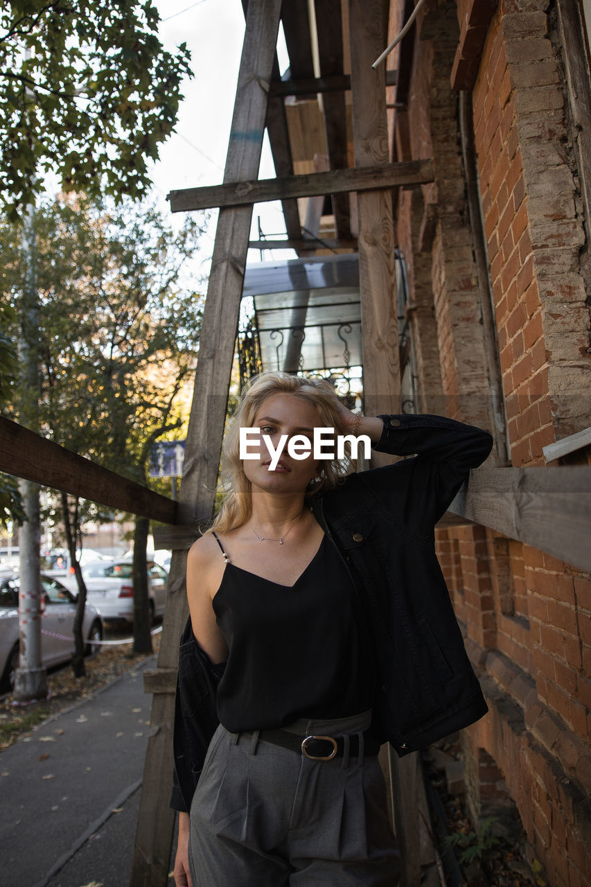 Portrait of woman standing against built structure