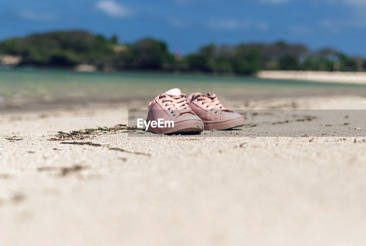 Close-up of shoes on sand