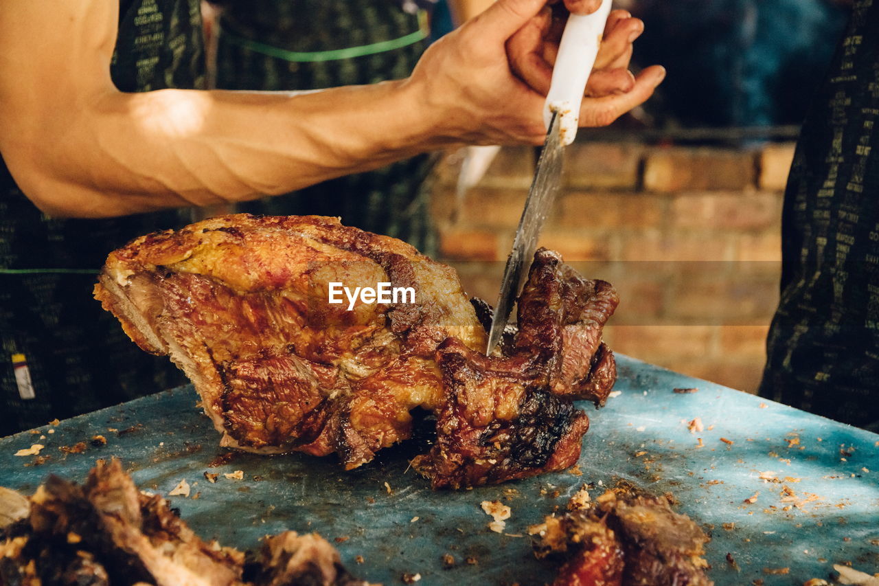 Close-up of man preparing food on barbecue grill