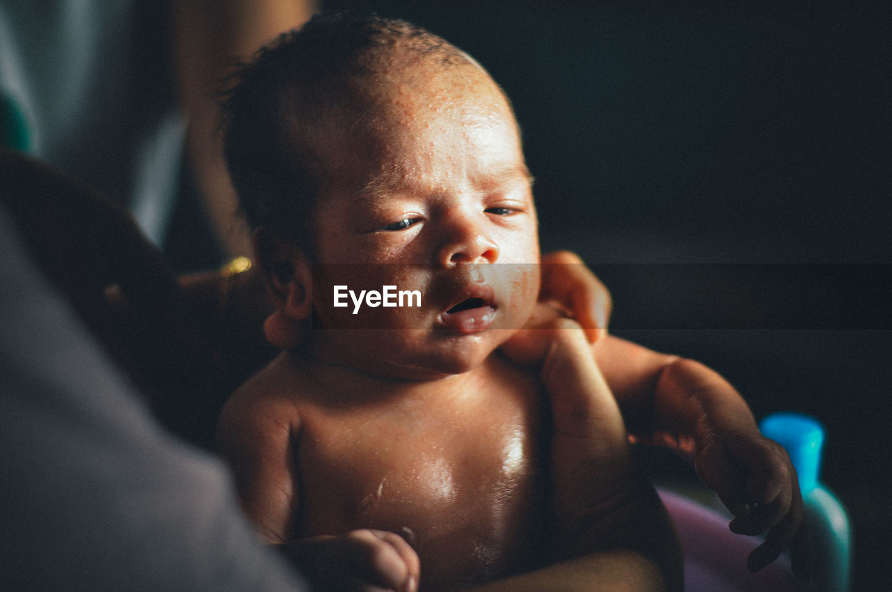 Close-up of hands holding newborn baby in hospital