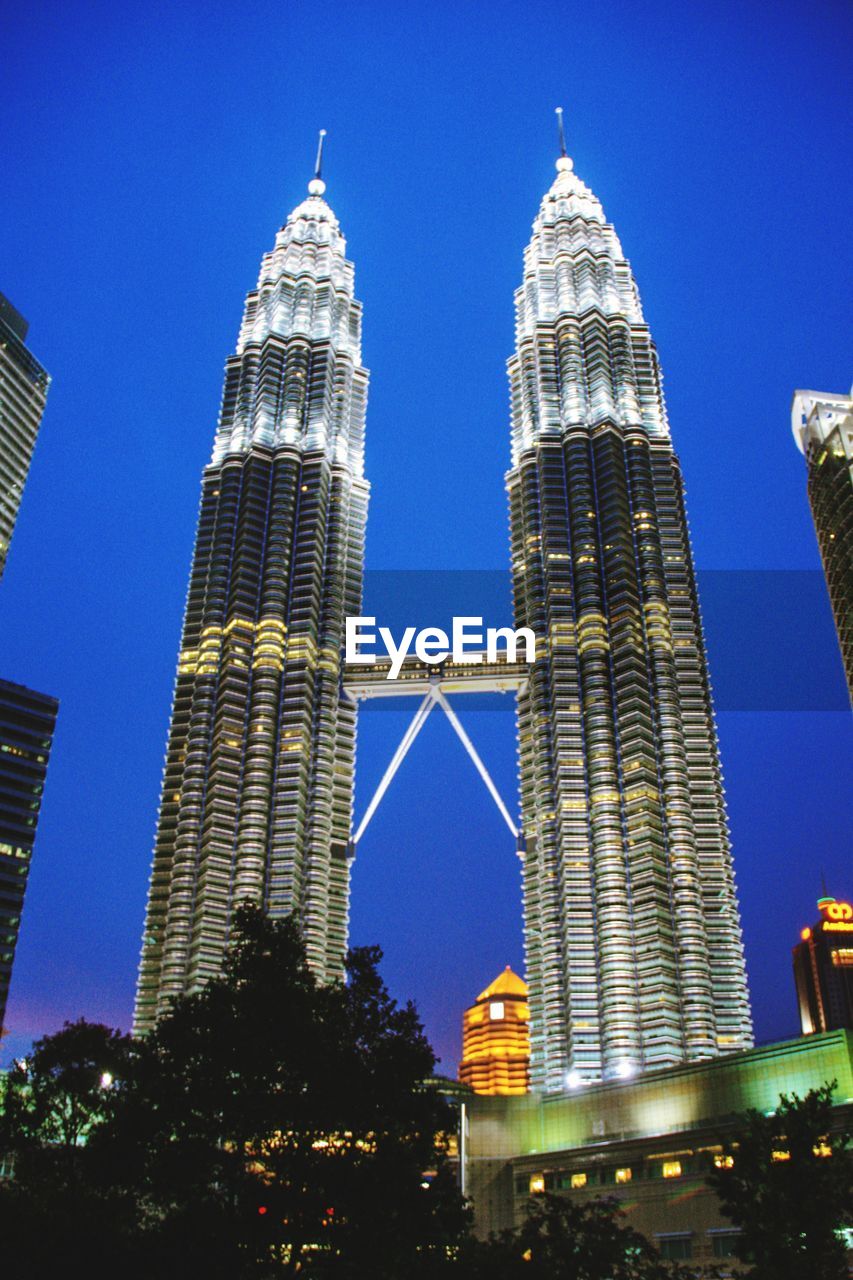 LOW ANGLE VIEW OF ILLUMINATED BUILDINGS AGAINST CLEAR SKY