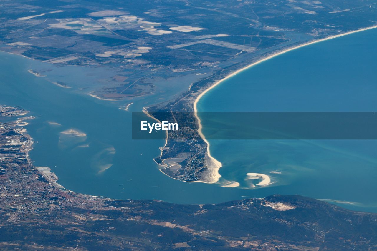 Aerial view of snowcapped mountains and sea against sky