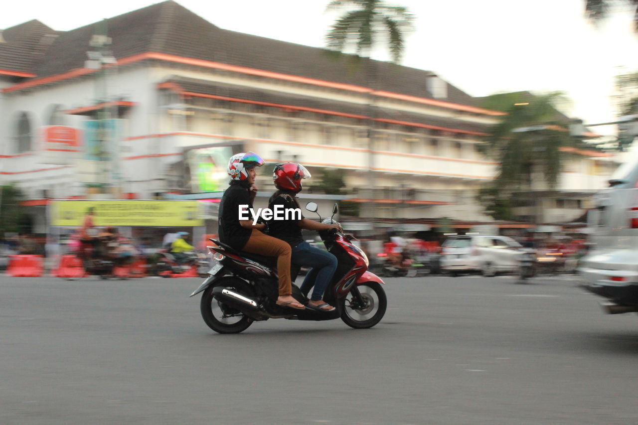 PEOPLE RIDING MOTORCYCLE ON ROAD