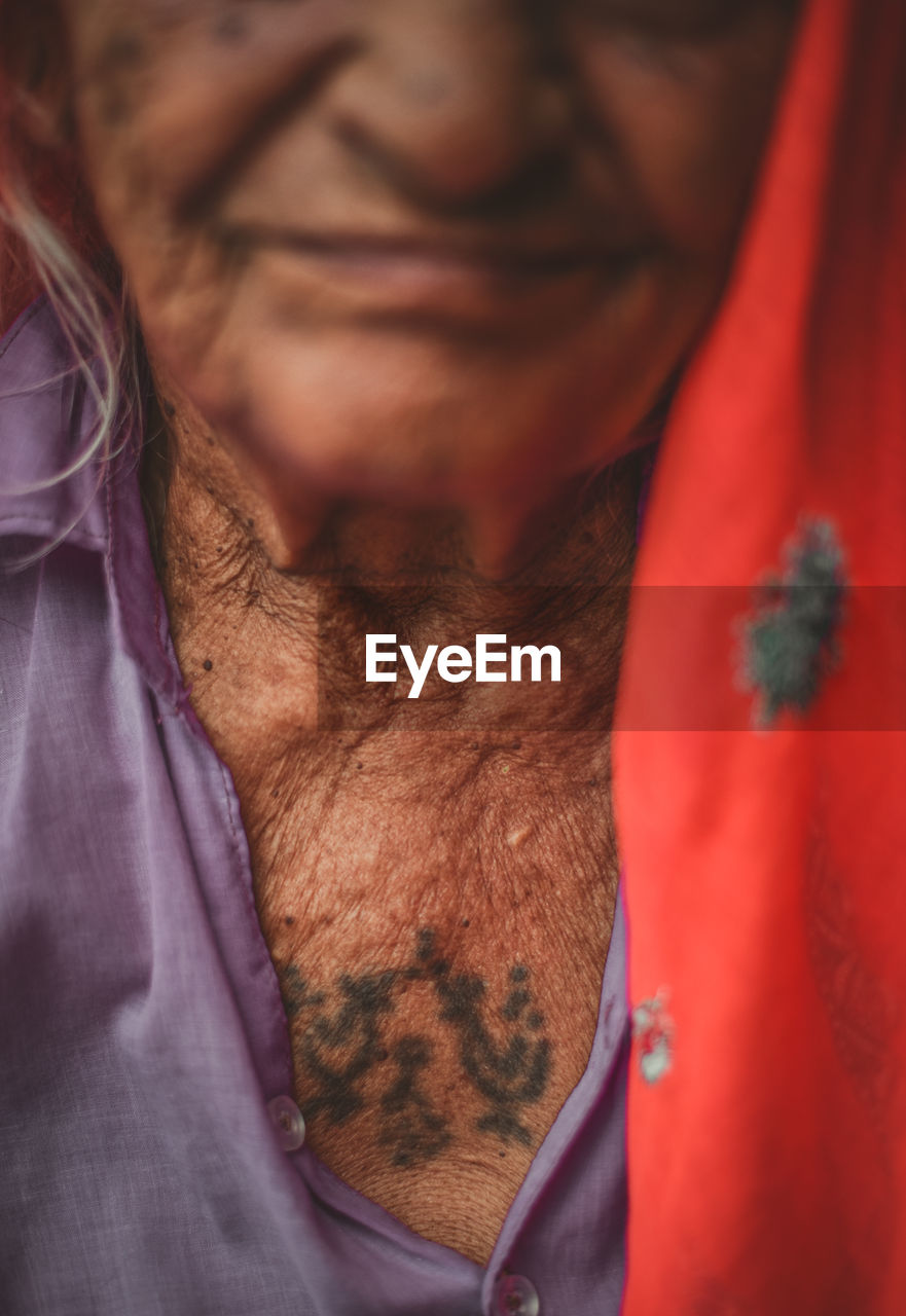 Mid section of senior adult woman with tattoo