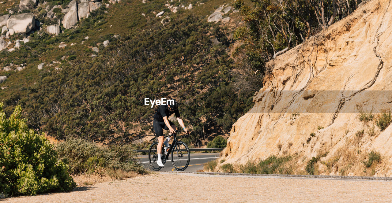 rear view of man riding bicycle on mountain