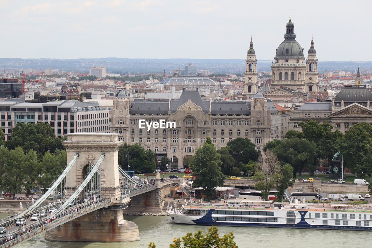 Arch bridge over river against buildings in city